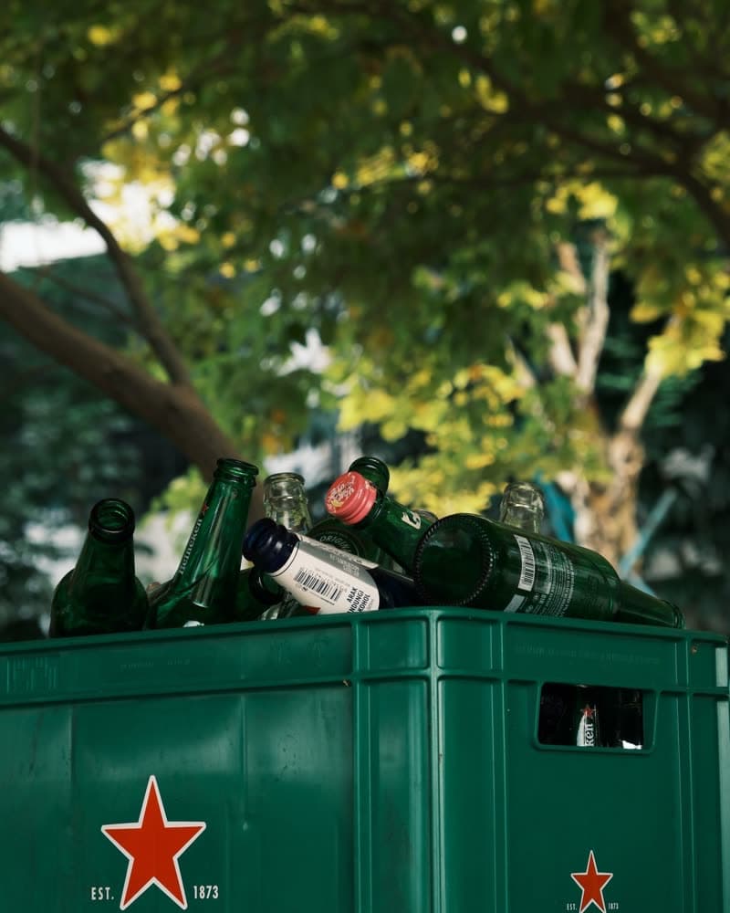 A crate of empty green beer bottles waiting outside for collection