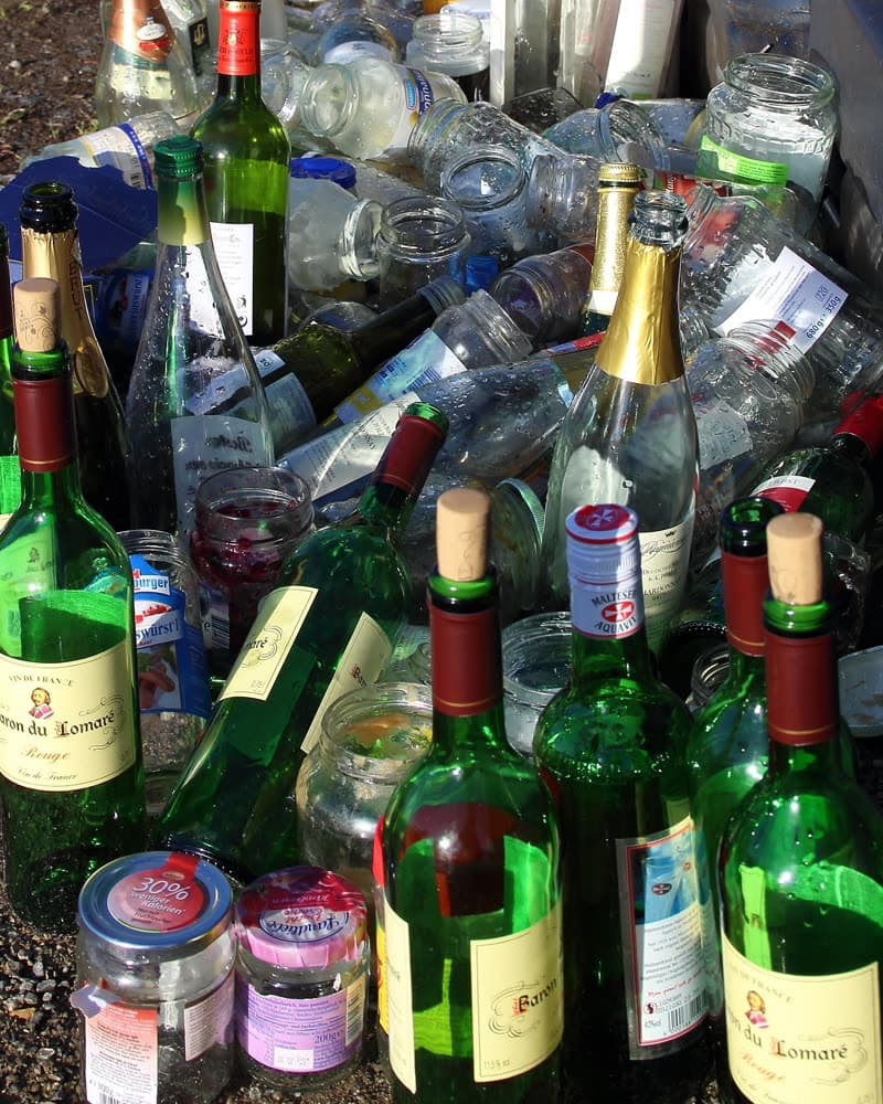 Empty wine bottles and other beverage containers set out at the kerb for pickup