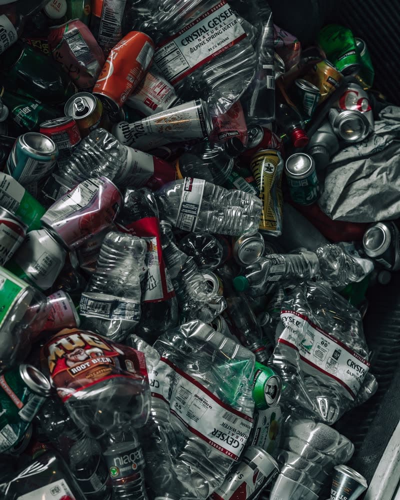 A bin filled with empty beverage cans and bottles ready to be returned