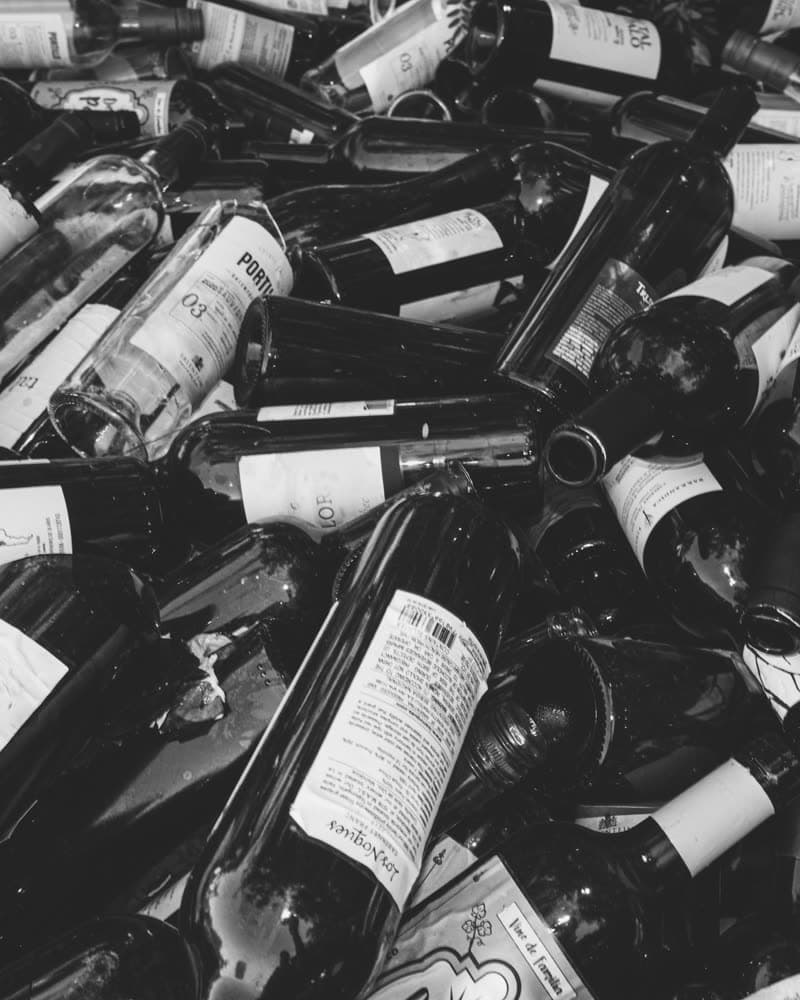 A large pile of empty wine bottles collected from one location